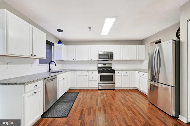 a kitchen with stainless steel appliances a refrigerator sink and wooden cabinets