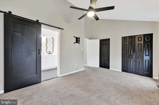 an empty room with closet and a chandelier fan