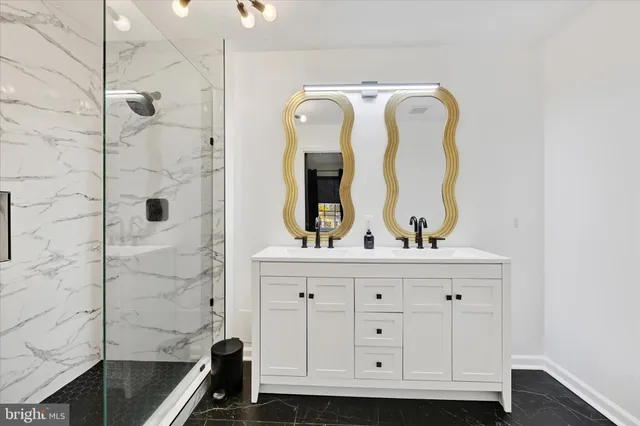 a bathroom with a granite countertop sink a mirror and shower