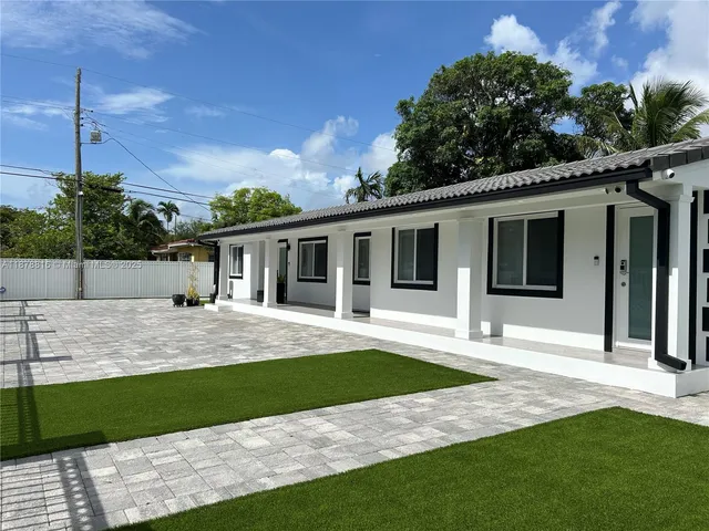 a front view of a house with a garden and yard