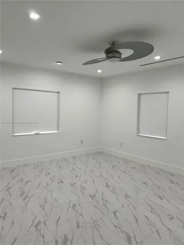 a view of an empty room and chandelier