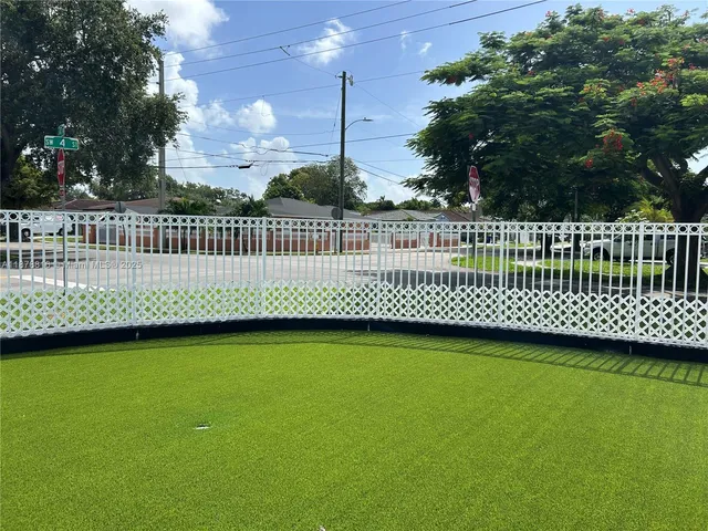 a view of a roof deck with wooden fence and trees