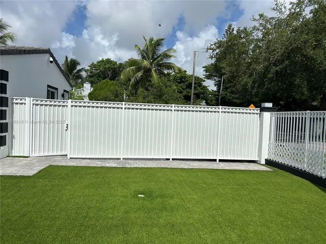a white house with green field in front of it