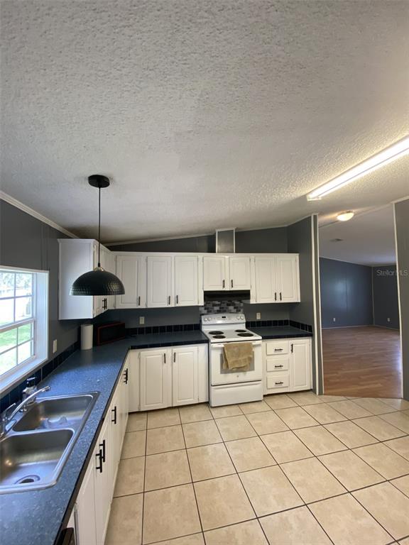 18851 Washington Lane Spring Hill, FL 34610 - Photo 17 of 25 a kitchen with stainless steel appliances granite countertop a sink counter space cabinets and a stove