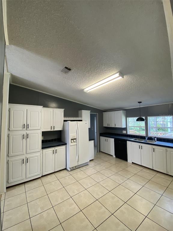 18851 Washington Lane Spring Hill, FL 34610 - Photo 18 of 25 a kitchen with granite countertop a refrigerator and white cabinets