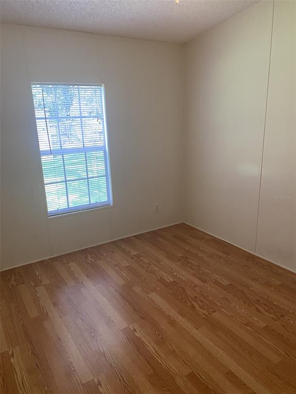 18851 Washington Lane Spring Hill, FL 34610 - Photo 24 of 25 an empty room with wooden floor and windows