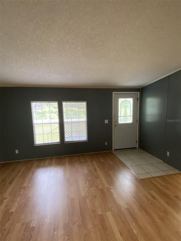18851 Washington Lane Spring Hill, FL 34610 - Photo 7 of 25 an empty room with wooden floor and windows