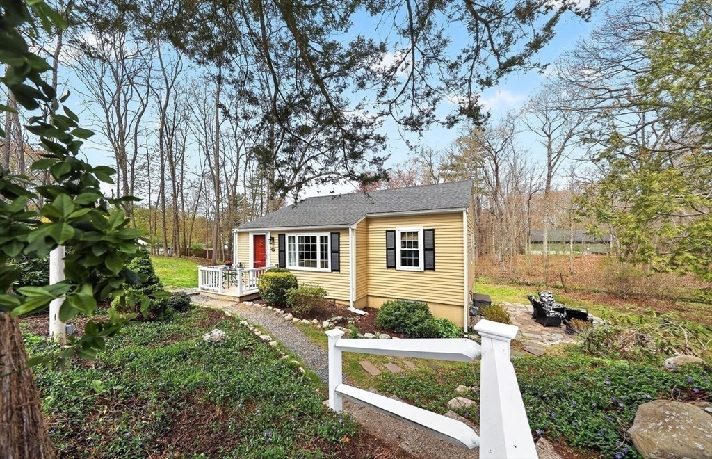 front view of house with a yard and potted plants