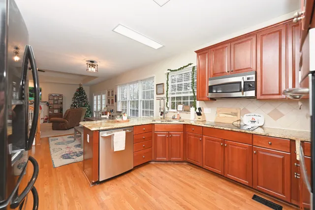 a kitchen with stainless steel appliances granite countertop wooden cabinets a sink and a stove