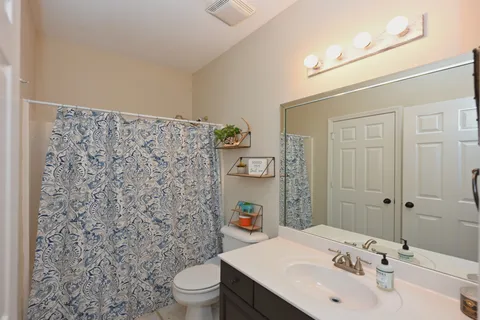 a spacious bathroom with a granite countertop sink and a mirror