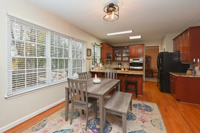 a view of a dining room with furniture a rug and wooden floor