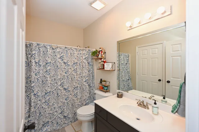 a bathroom with a sink a toilet and shower curtain