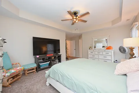 a bedroom with a bed and a flat tv screen on dresser