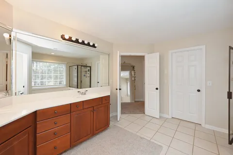 a spacious bathroom with a granite countertop sink mirror and bathtub