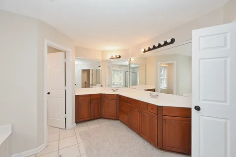 a spacious bathroom with a granite countertop sink and a mirror