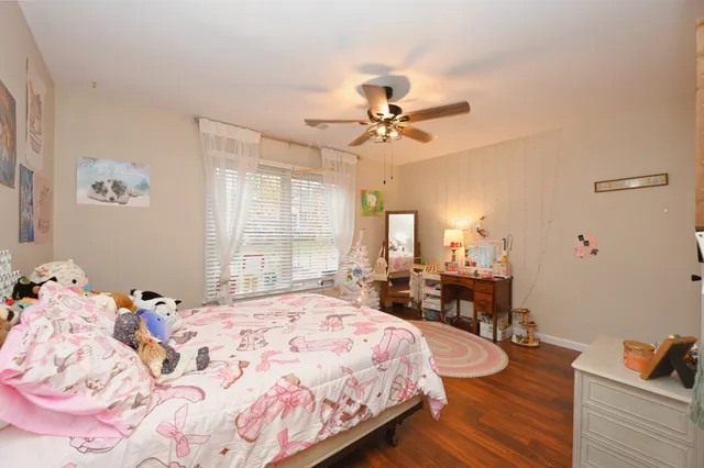 a bedroom with a bed and wooden floor
