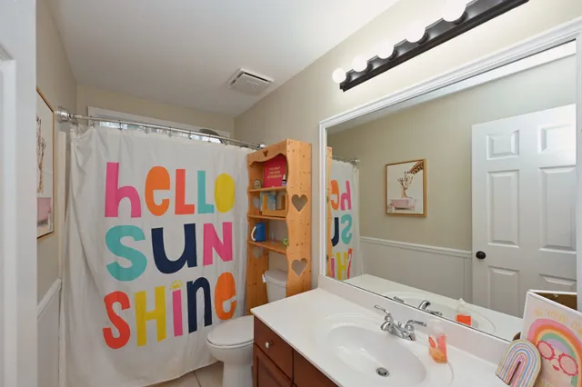 a bathroom with a sink a toilet and shower curtain