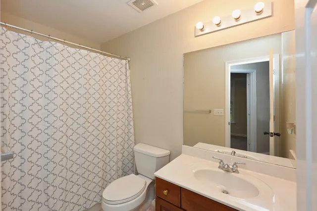 a bathroom with a sink a toilet and shower curtain