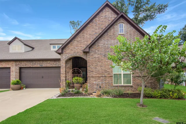 a front view of a house with a garden and yard
