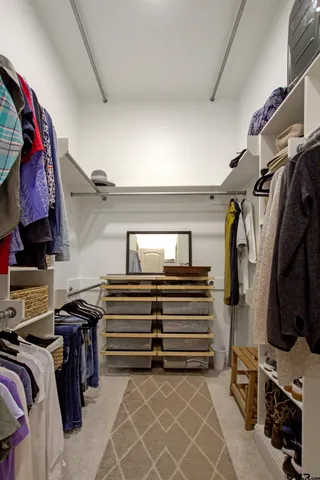 a view of walk in closet with clothes and shoes
