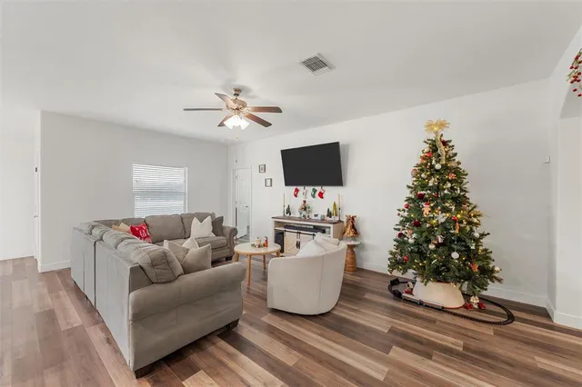 a living room with a couch a flat screen tv and a potted plant