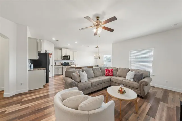 a living room with furniture and a view of kitchen