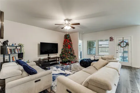 a living room with furniture a chandelier and a flat screen tv