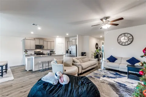 a living room with furniture a clock and wooden floor