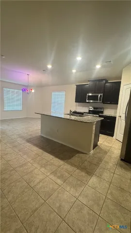 a view of kitchen with stainless steel appliances granite countertop a sink and a stove