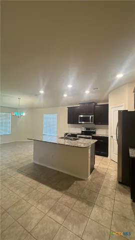 a kitchen with stainless steel appliances granite countertop a refrigerator and a sink