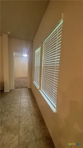 a view of a hallway with an empty room and a window