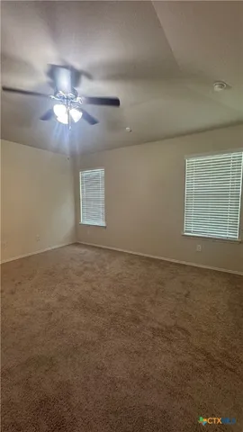 a view of a livingroom with a ceiling fan and window