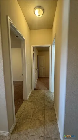 a view of a hallway with wooden shelves