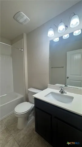 a bathroom with a sink a toilet a mirror and shower