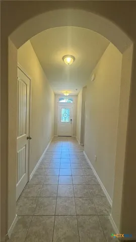 a view of hallway with a window and a chandelier