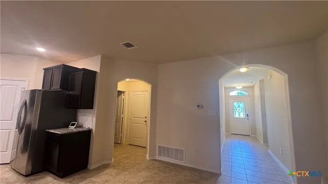a view of a kitchen with refrigerator and wooden floor