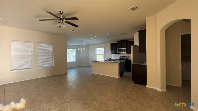 a view of a kitchen with furniture stainless steel appliances and a ceiling fan