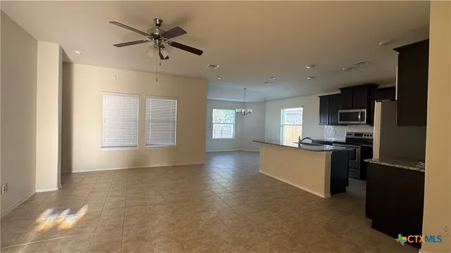 a view of kitchen with sink refrigerator and window