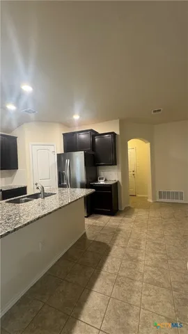 a large kitchen with a stove a sink and a microwave