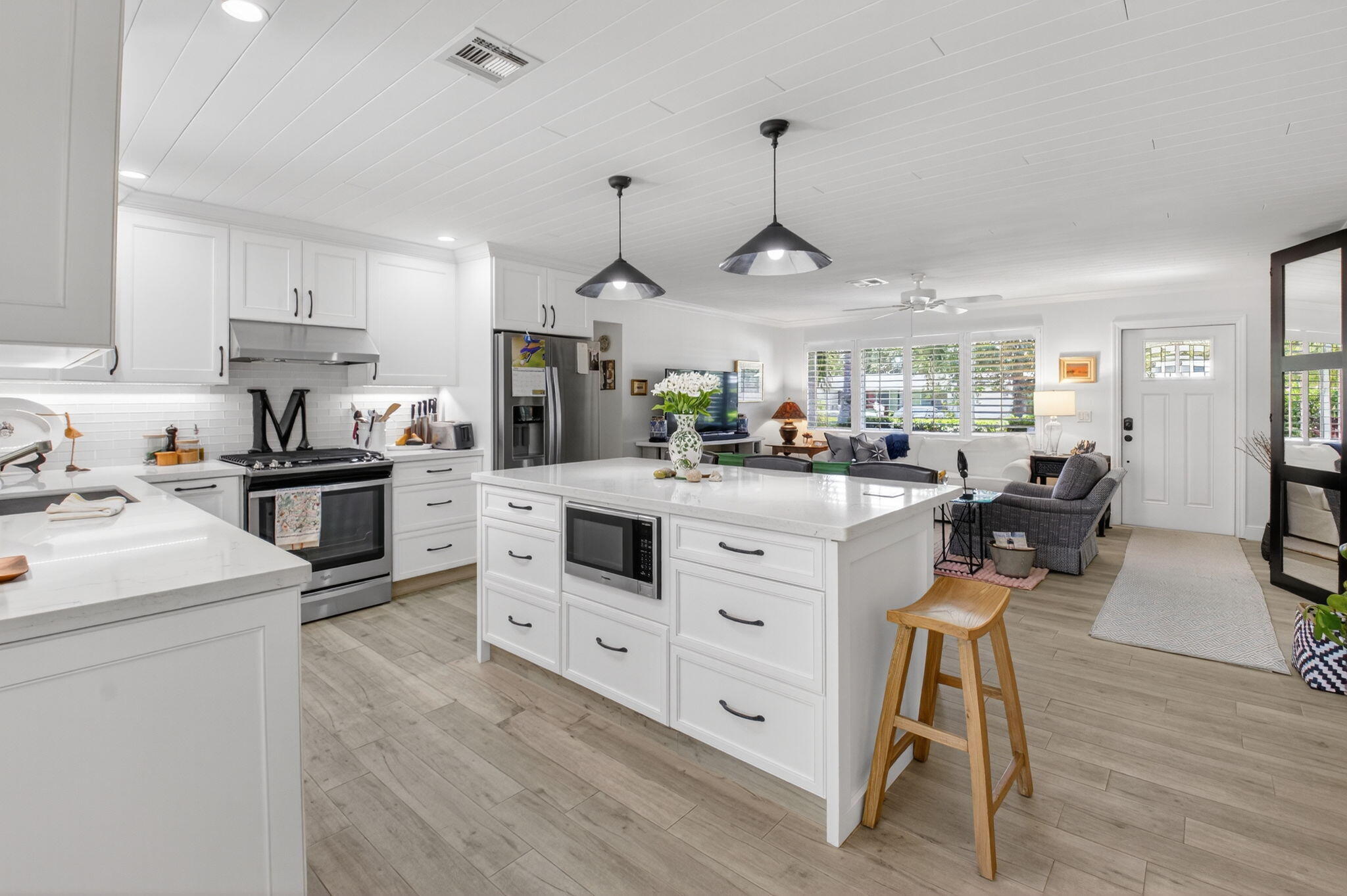 2702 Southwest 6th Street Boynton Beach, FL 33435 - Photo 12 of 49 a kitchen with stainless steel appliances kitchen island granite countertop a sink a stove and a refrigerator