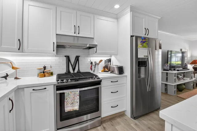 a kitchen with stainless steel appliances granite countertop a refrigerator stove and sink