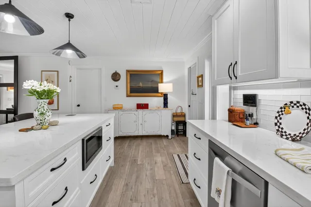 a kitchen that has a lot of cabinets and wooden floor