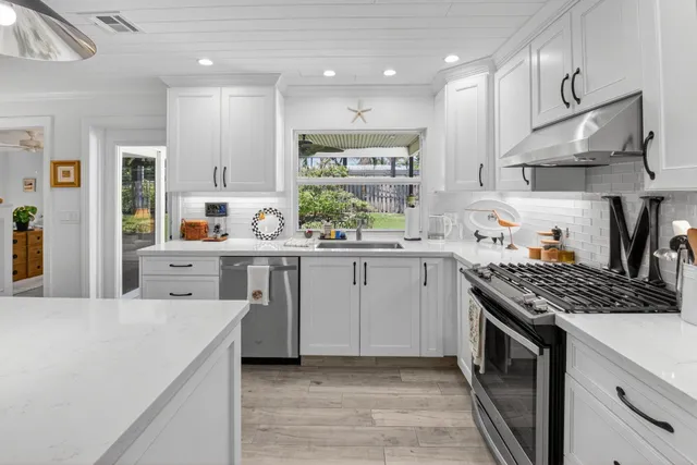 a kitchen with stainless steel appliances a sink stove and cabinets