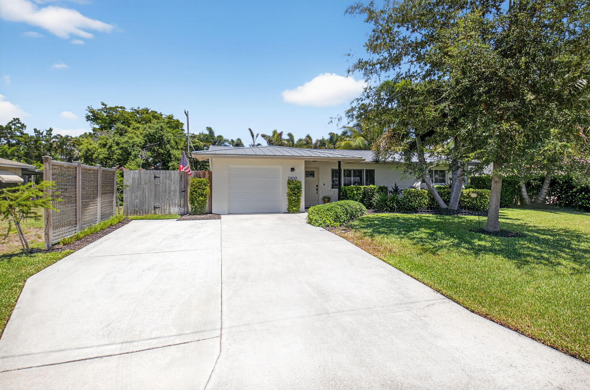 2702 Southwest 6th Street Boynton Beach, FL 33435 - Photo 2 of 49 a view of a white house with a small yard and a large tree