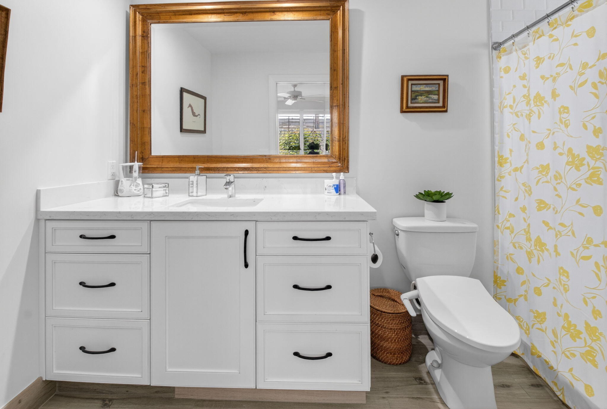 2702 Southwest 6th Street Boynton Beach, FL 33435 - Photo 22 of 49 a bathroom with a sink a toilet a mirror and shower curtain