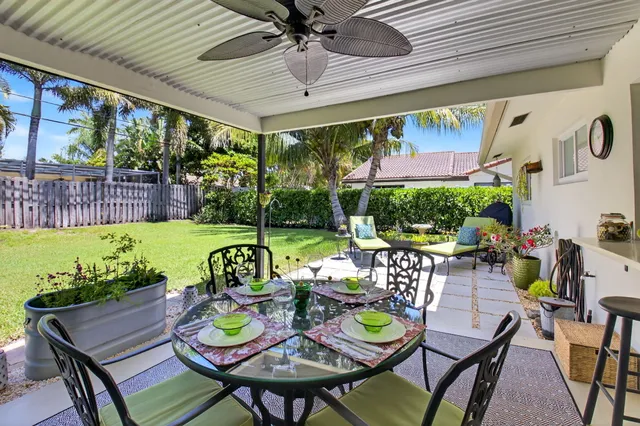 a view of a patio with a dining table and chairs with a garden