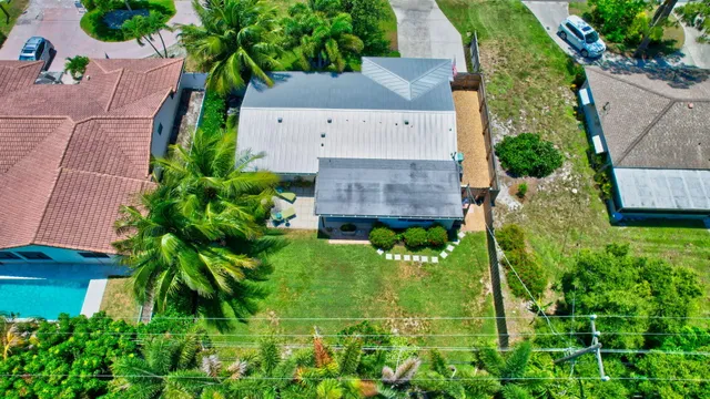 an aerial view of a house with a yard and large trees