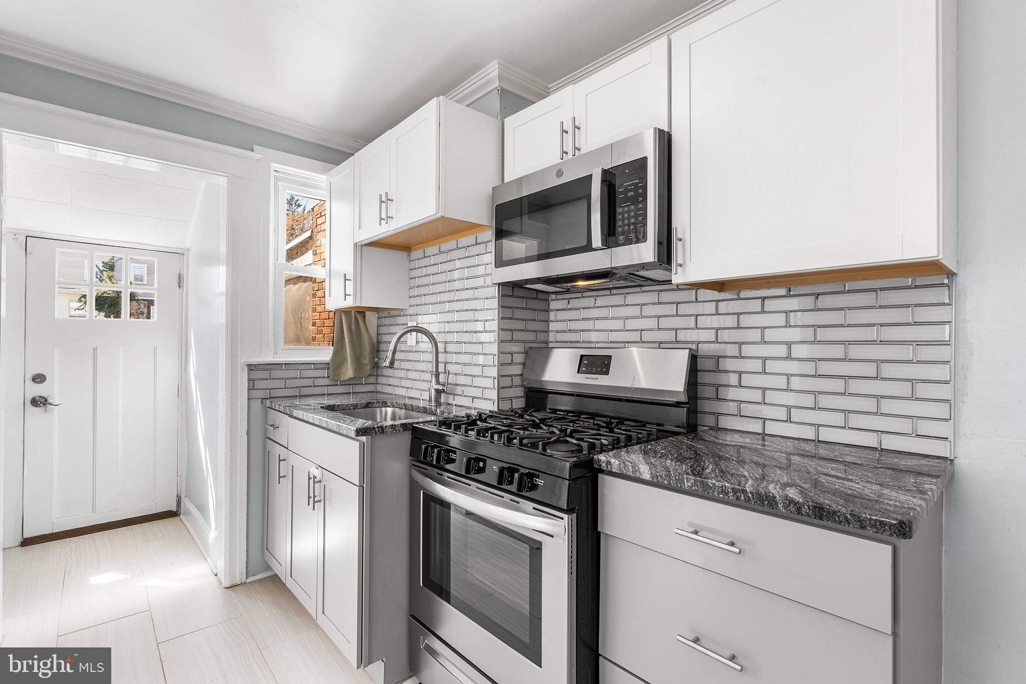 424 Cypress Street Lansdowne, PA 19050 - Photo 12 of 32 a kitchen with stainless steel appliances granite countertop a stove and a microwave