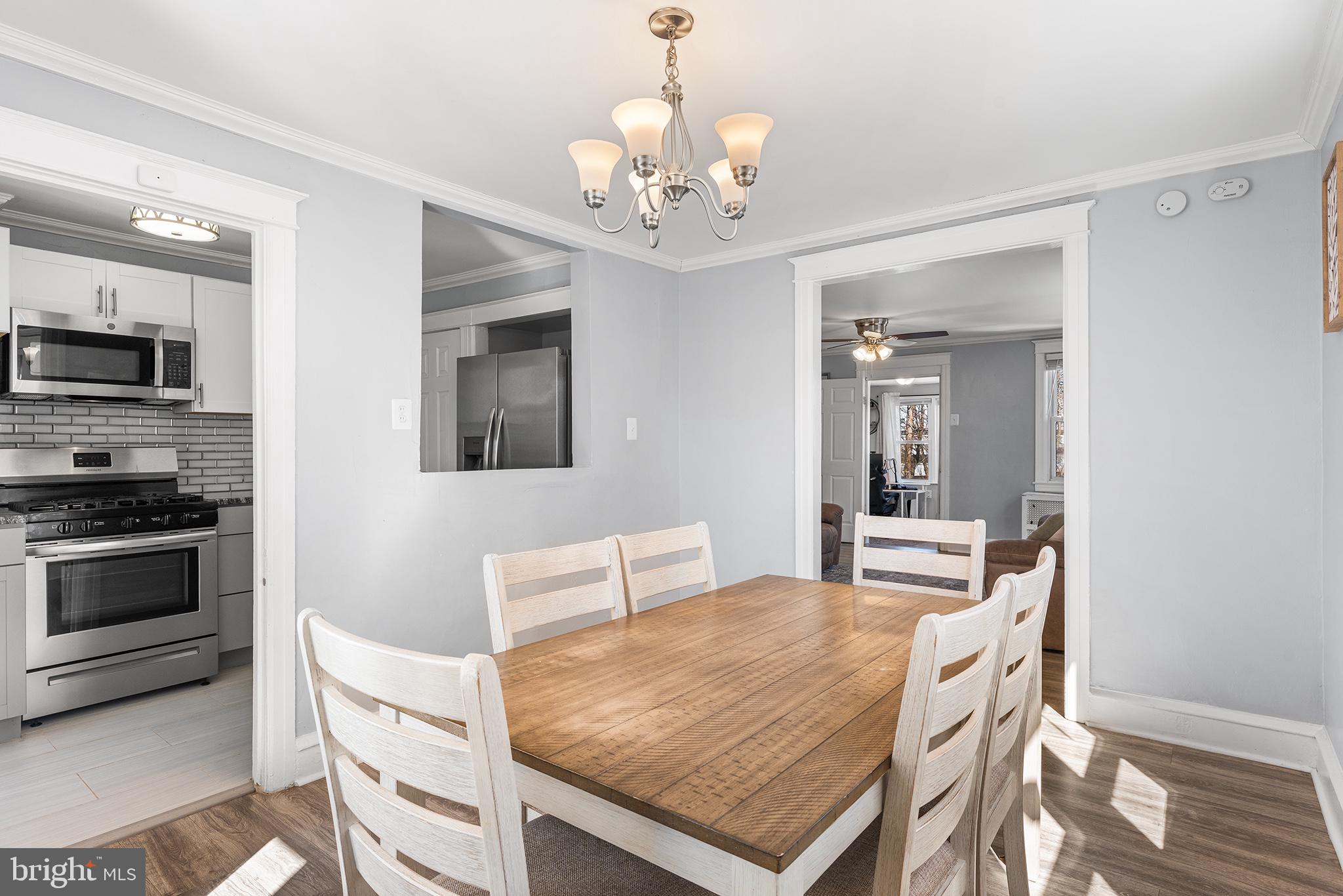 424 Cypress Street Lansdowne, PA 19050 - Photo 10 of 32 a dining room with wooden floor a chandelier a wooden table and chairs