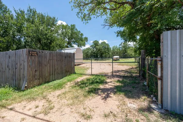 a view of a backyard with wooden fence
